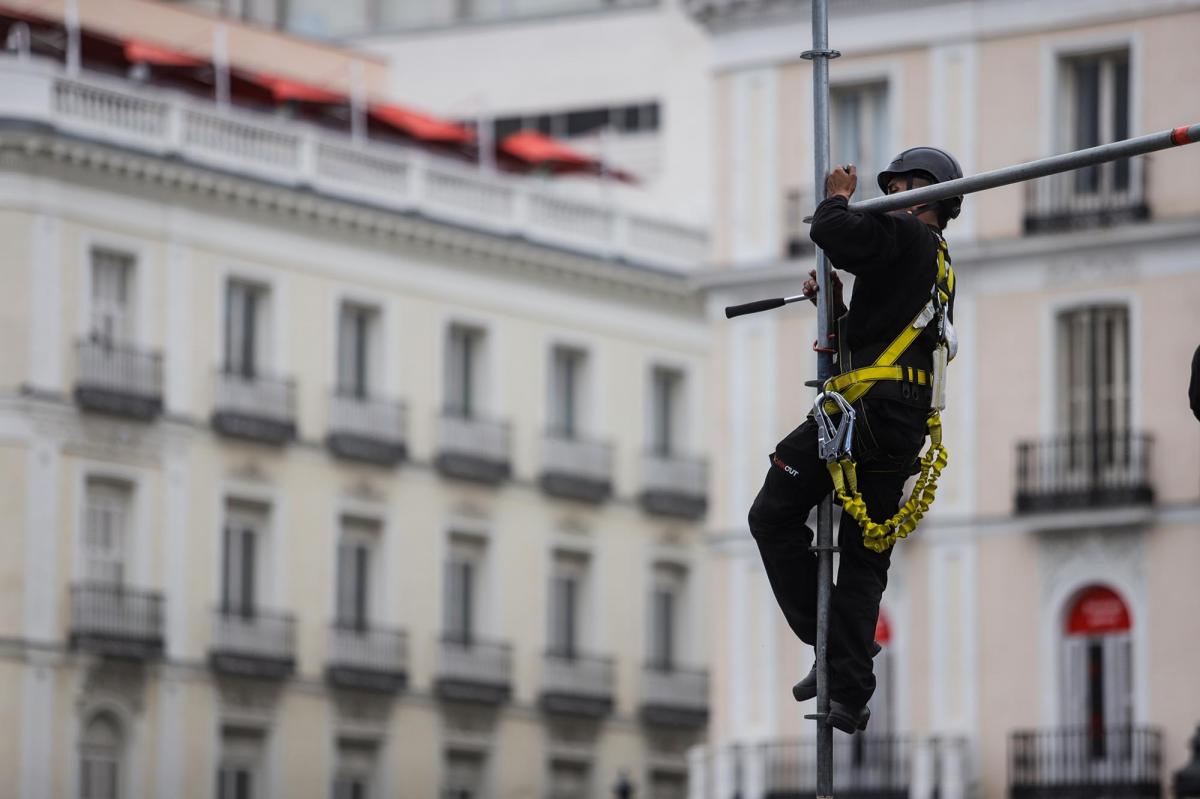 Trabajador montando un andamio en la Puerta del Sol de Madrid