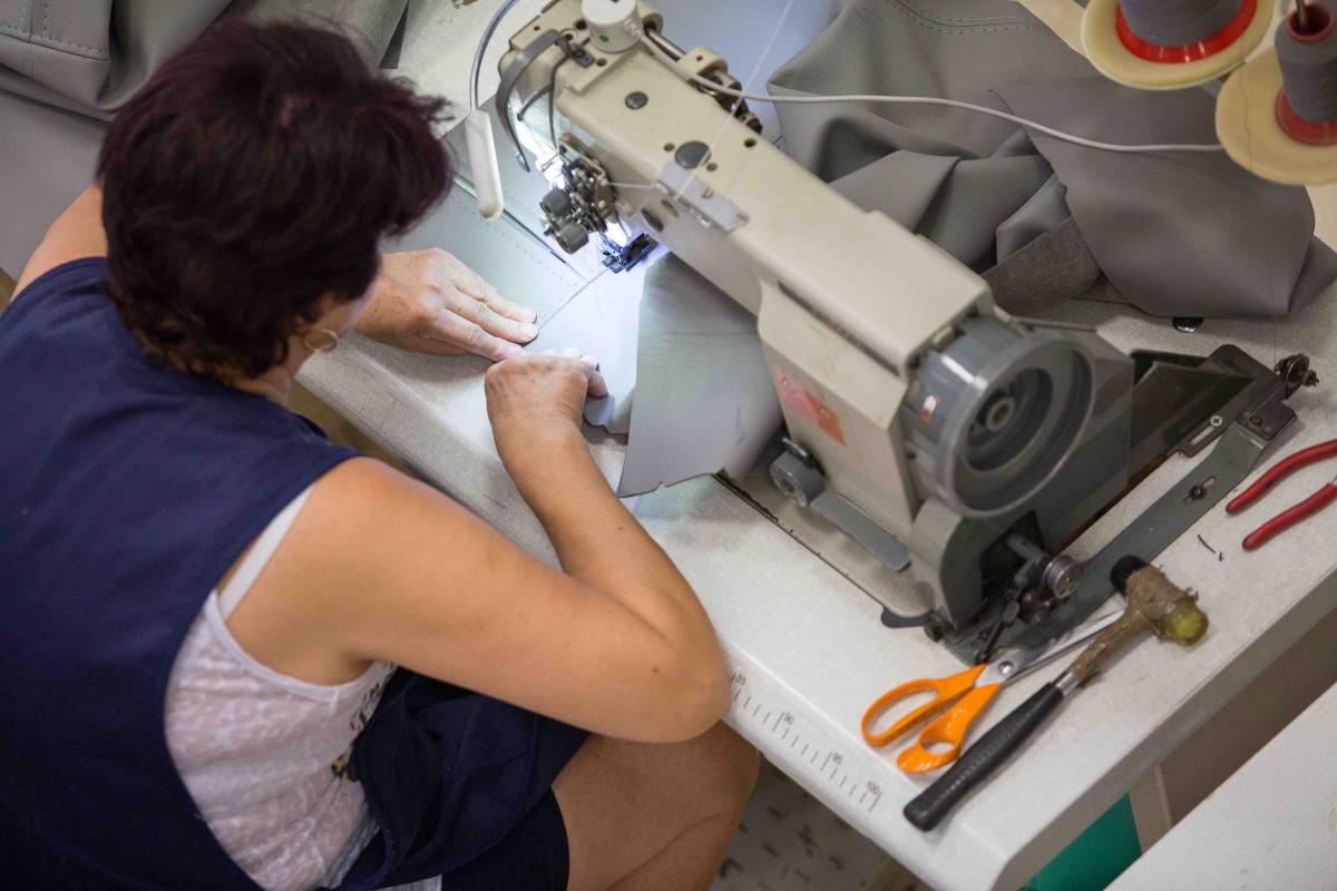 Trabajadora de la industria textil cosiendo una pieza de cuero