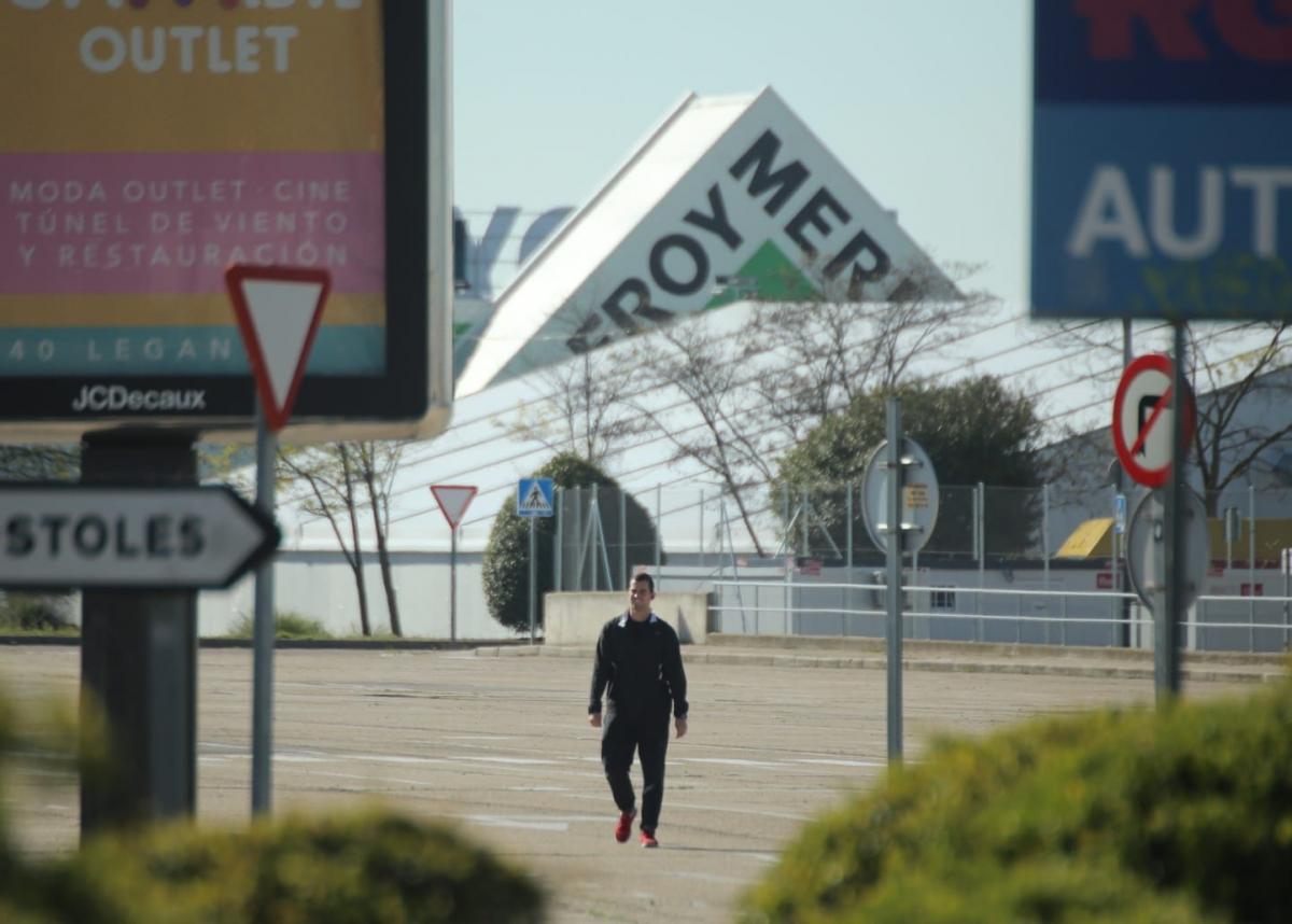 Un hombre camina solitario por la zona comercial Parque Oeste en Móstoles durante la crisis del coronavirus